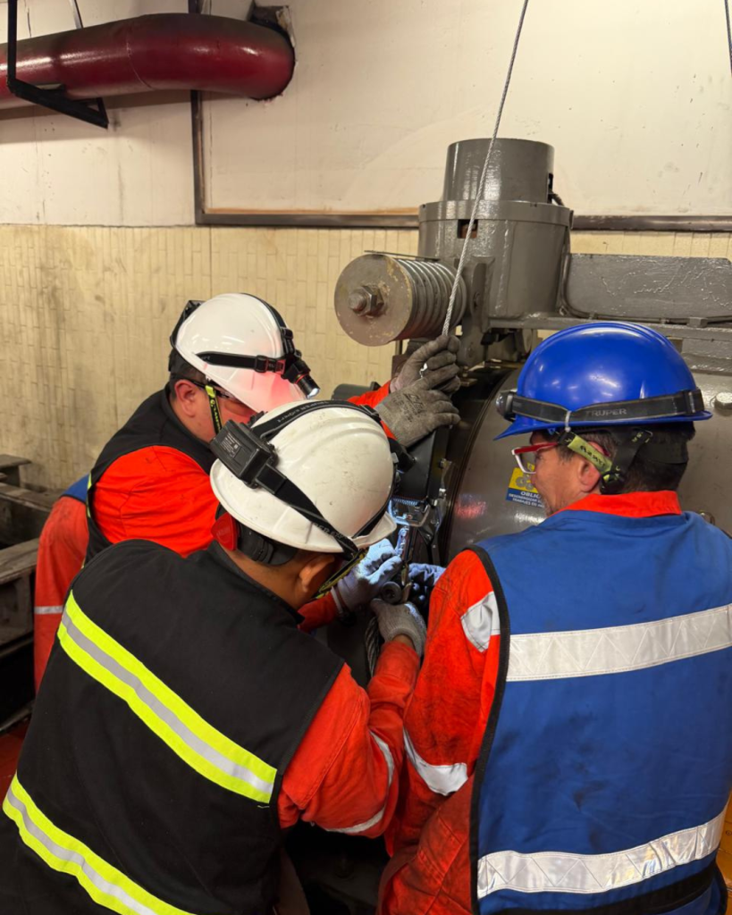 tres personas con maquinaria de elevador